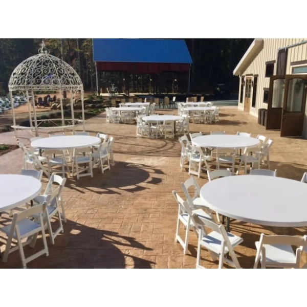 white resin chairs around circle tables outside